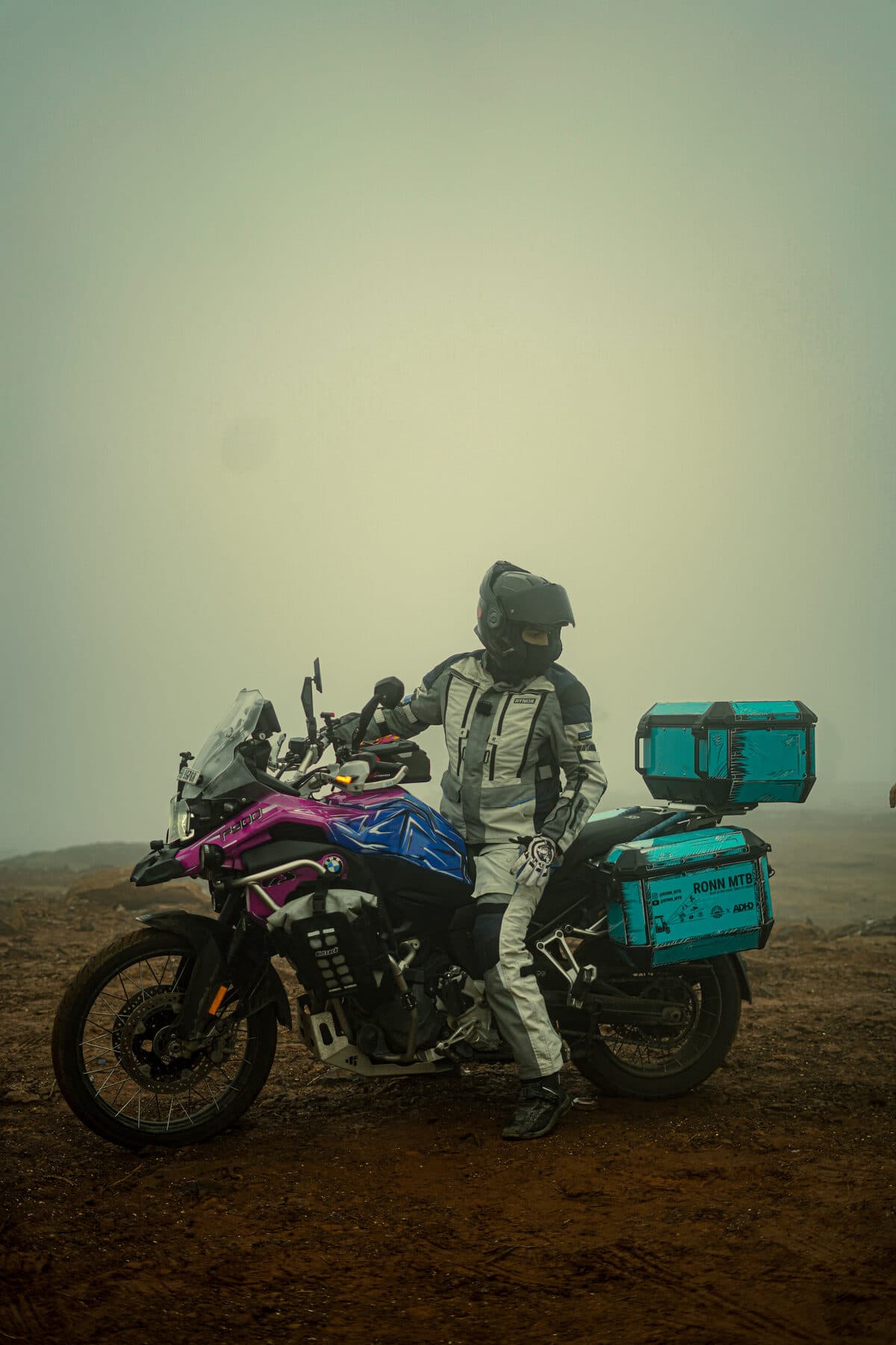 Ronn beside his touring motorcycle in fog on a mountain road